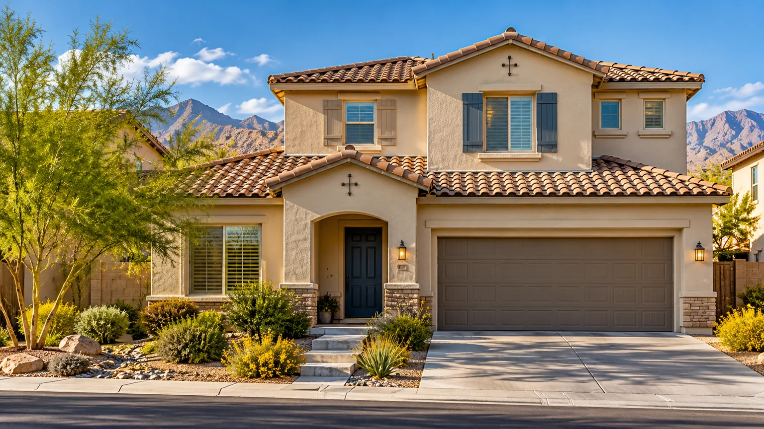 Wide street view of modest two-story stucco house with beautiful finished tile roof under crisp desert sky