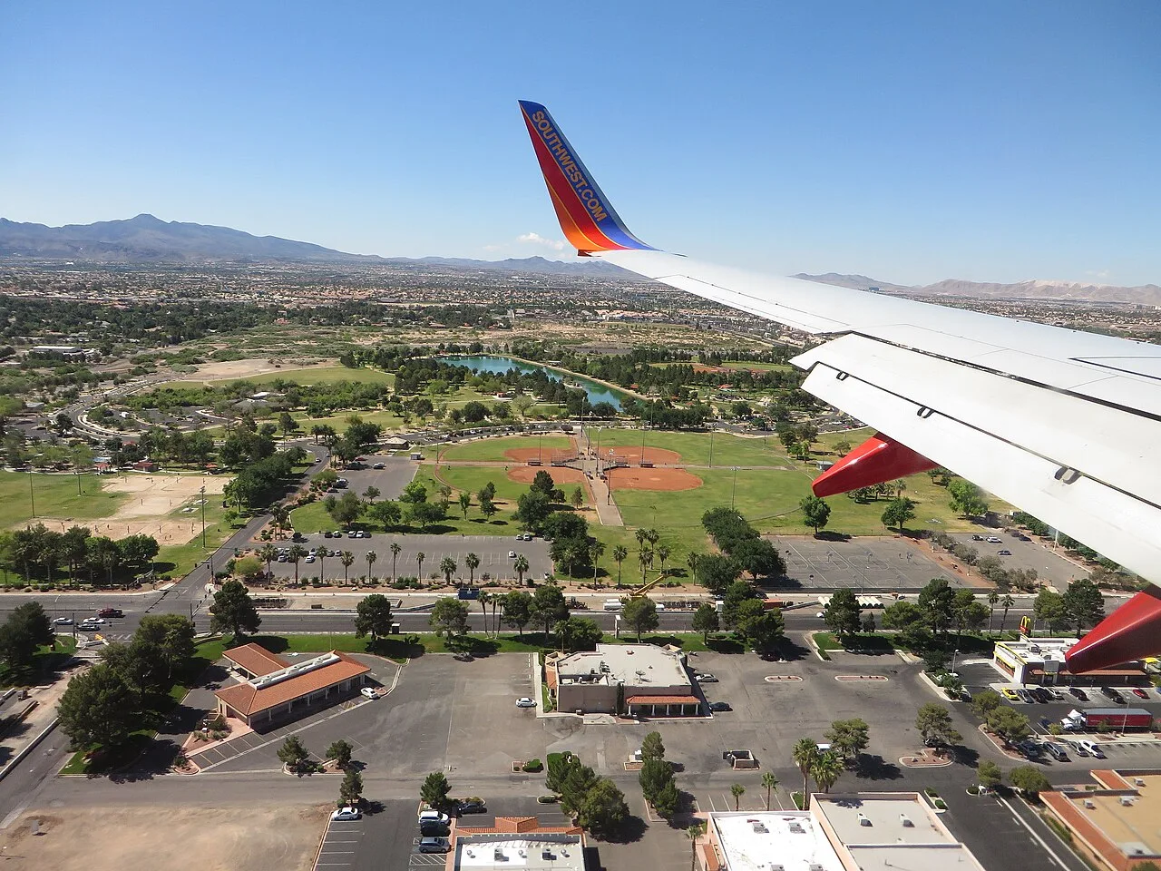 Aerial view of Sunset Park with an airplane wing in the foreground